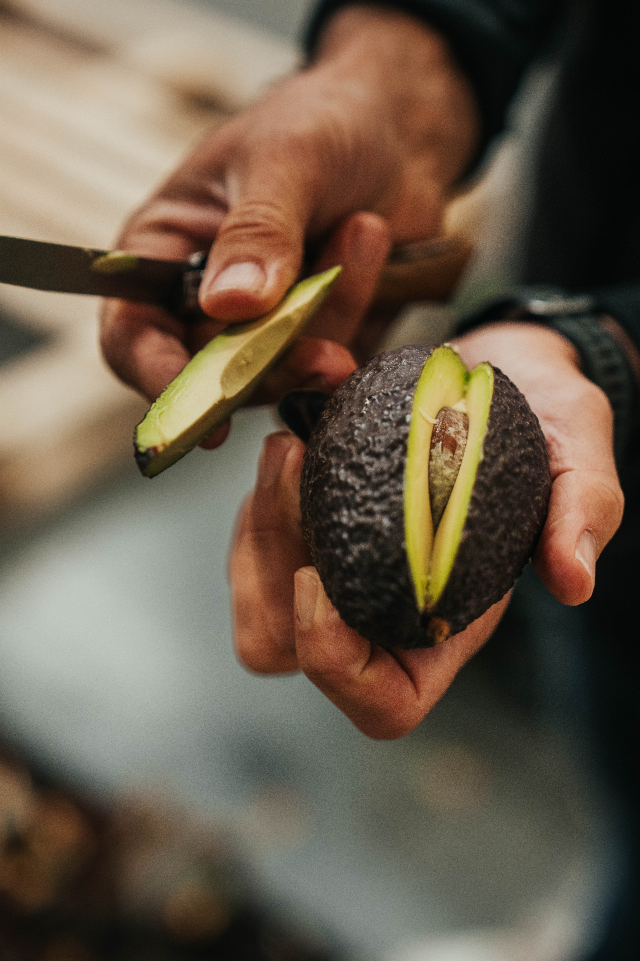 Avocat mûr coupé en tranches dans les mains du primeur